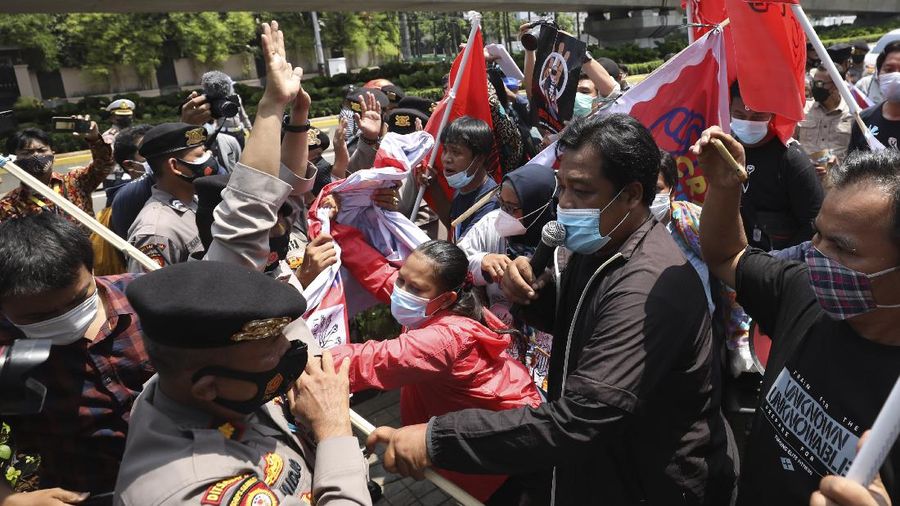 Aktivis bentrok dengan petugas polisi saat mereka dibubarkan selama unjuk rasa menentang kudeta militer Myanmar di dekat Sekretariat Perhimpunan Bangsa-Bangsa Asia Tenggara (ASEAN) menjelang pertemuan para pemimpin di Jakarta, Indonesia, Sabtu, 24 April 2021. (AP/Dita Alangkara)