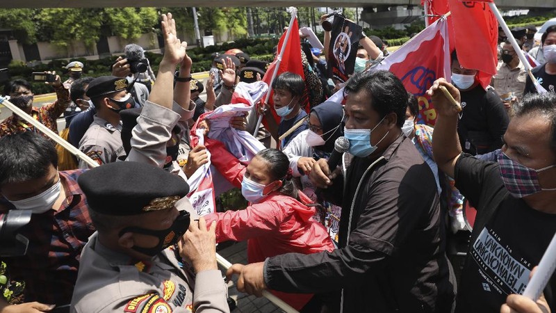 Aktivis bentrok dengan petugas polisi saat mereka dibubarkan selama unjuk rasa menentang kudeta militer Myanmar di dekat Sekretariat Perhimpunan Bangsa-Bangsa Asia Tenggara (ASEAN) menjelang pertemuan para pemimpin di Jakarta, Indonesia, Sabtu, 24 April 2021. (AP/Dita Alangkara)