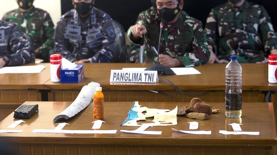 Panglima TNI Angkatan Laut Yudo Margono, kiri depan, Panglima TNI Hadi Tjahjanto, tengah, dan Kapolri Listyo Sigit Prabowo, kanan, berbicara kepada media saat mereka menampilkan puing-puing yang ditemukan di perairan selama pencarian kapal selam TNI AL KRI Nanggala di Ngurah Pangkalan Udara Militer Rai di Bali, Sabtu (24/4/2021). (AP/Firdia Lisnawati)