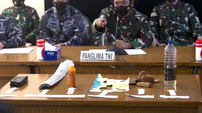 Panglima TNI Angkatan Laut Yudo Margono, kiri depan, Panglima TNI Hadi Tjahjanto, tengah, dan Kapolri Listyo Sigit Prabowo, kanan, berbicara kepada media saat mereka menampilkan puing-puing yang ditemukan di perairan selama pencarian kapal selam TNI AL KRI Nanggala di Ngurah Pangkalan Udara Militer Rai di Bali, Sabtu (24/4/2021). (AP/Firdia Lisnawati)