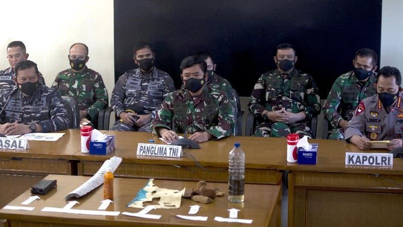 Panglima TNI Angkatan Laut Yudo Margono, kiri depan, Panglima TNI Hadi Tjahjanto, tengah, dan Kapolri Listyo Sigit Prabowo, kanan, berbicara kepada media saat mereka menampilkan puing-puing yang ditemukan di perairan selama pencarian kapal selam TNI AL KRI Nanggala di Ngurah Pangkalan Udara Militer Rai di Bali, Sabtu (24/4/2021). (AP/Firdia Lisnawati)