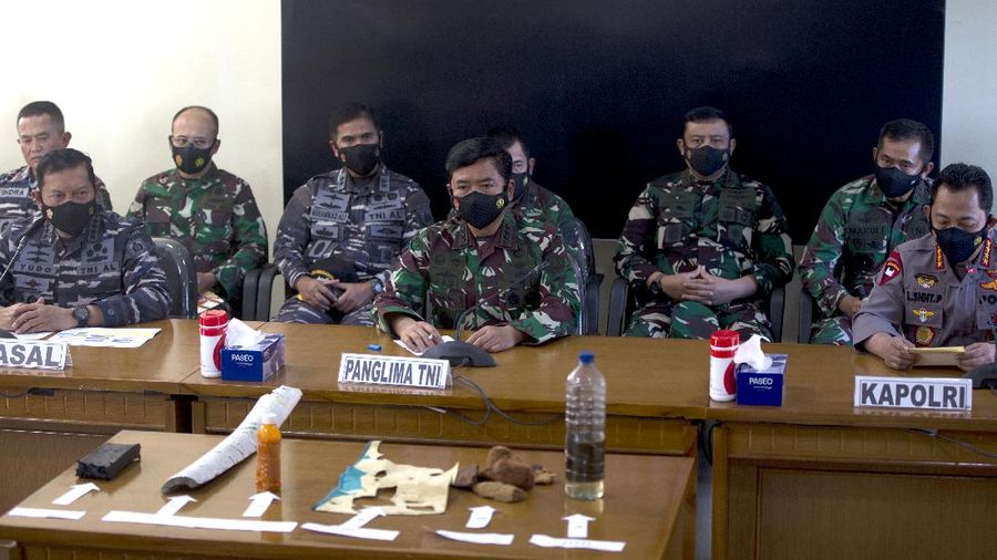 Panglima TNI Angkatan Laut Yudo Margono, kiri depan, Panglima TNI Hadi Tjahjanto, tengah, dan Kapolri Listyo Sigit Prabowo, kanan, berbicara kepada media saat mereka menampilkan puing-puing yang ditemukan di perairan selama pencarian kapal selam TNI AL KRI Nanggala di Ngurah Pangkalan Udara Militer Rai di Bali, Sabtu (24/4/2021). (AP/Firdia Lisnawati)