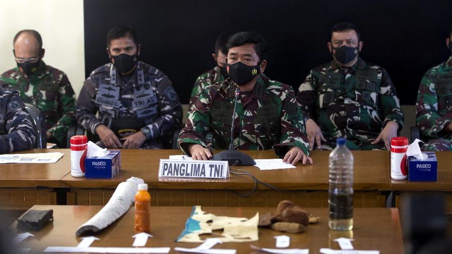 Panglima TNI Angkatan Laut Yudo Margono, kiri depan, Panglima TNI Hadi Tjahjanto, tengah, dan Kapolri Listyo Sigit Prabowo, kanan, berbicara kepada media saat mereka menampilkan puing-puing yang ditemukan di perairan selama pencarian kapal selam TNI AL KRI Nanggala di Ngurah Pangkalan Udara Militer Rai di Bali, Sabtu (24/4/2021). (AP/Firdia Lisnawati)