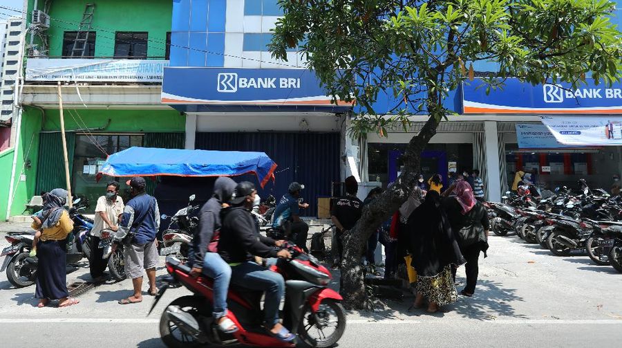 Sejumlah warga mendatangi Bank BRI di Jakarta untuk mendapatkan Banpres Produktif untuk Usaha Mikro (BPUM) sebesar 1,2 juta, Senin (26/4/2021). Program bernama Bantuan Produktif Usaha Mikro (BPUM) itu ditargetkan bisa menyalurkan ke 12,8 juta penerima selama tahun 2021. (CNBC Indonesia/ Tri Susilo)