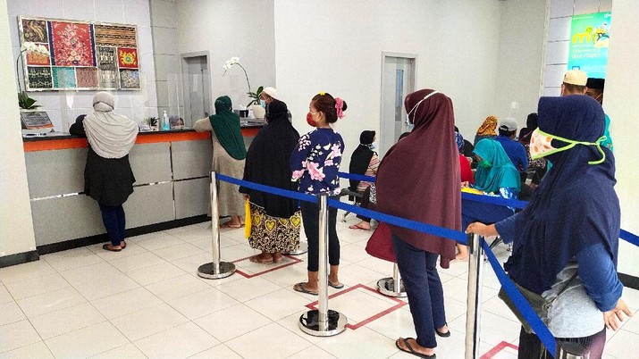 Antrian Warga Ambil BLT UMKM (CNBC Indonesia/ Tri Susilo) Sejumlah warga mendatangi Bank BRI di Jakarta untuk mendapatkan Banpres Produktif untuk Usaha Mikro (BPUM) sebesar 1,2 juta, Senin (26/4/2021). Program bernama Bantuan Produktif Usaha Mikro (BPUM) itu ditargetkan bisa menyalurkan ke 12,8 juta penerima selama tahun 2021. (CNBC Indonesia/ Tri Susilo)