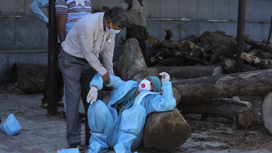 A relative of a person who died of COVID-19 breaks down during cremation in Jammu, India, Sunday, April 25, 2021. India’s crematoriums and burial grounds are being overwhelmed by the devastating new surge of infections tearing through the populous country with terrifying speed, depleting the supply of life-saving oxygen to critical levels and leaving patients to die while waiting in line to see doctors. (AP Photo/Channi Anand)