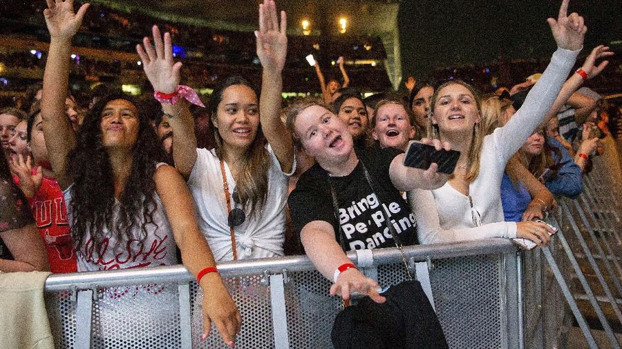 Fans watch the New Zealand band Six60 perform at Eden Park in Auckland, New Zealand, Saturday, April 24, 2021. Six60 is being billed as the biggest live act in the world since the coronavirus pandemic struck after New Zealand stamped out the spread of the virus, allowing life to return to normal. On Saturday, the band played a remarkable finale to their latest tour, performing in front of 50,000 people at the first-ever concert at Auckland's Eden Park.(AP Photo/David Rowland)