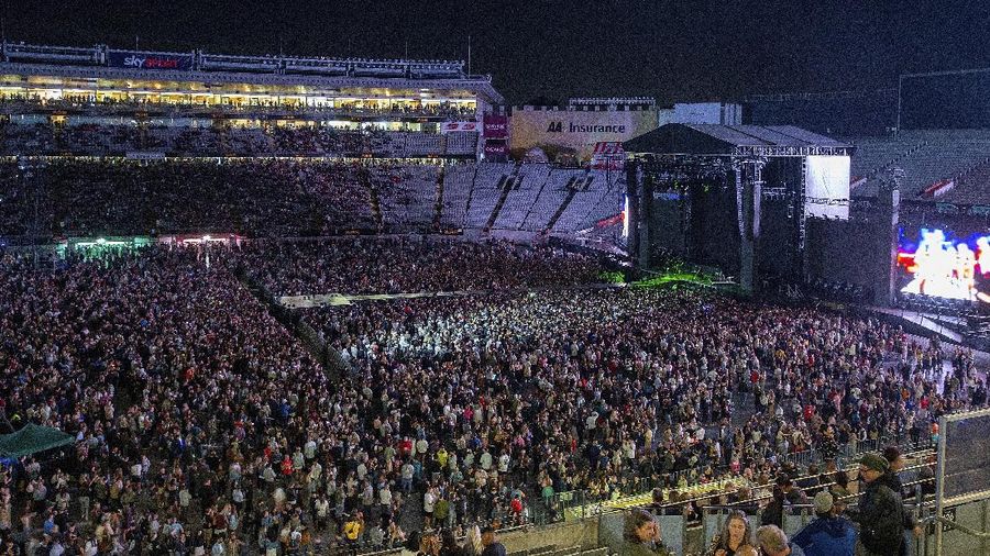 Fans watch the New Zealand band Six60 perform at Eden Park in Auckland, New Zealand, Saturday, April 24, 2021. Six60 is being billed as the biggest live act in the world since the coronavirus pandemic struck after New Zealand stamped out the spread of the virus, allowing life to return to normal. On Saturday, the band played a remarkable finale to their latest tour, performing in front of 50,000 people at the first-ever concert at Auckland's Eden Park.(AP Photo/David Rowland)
