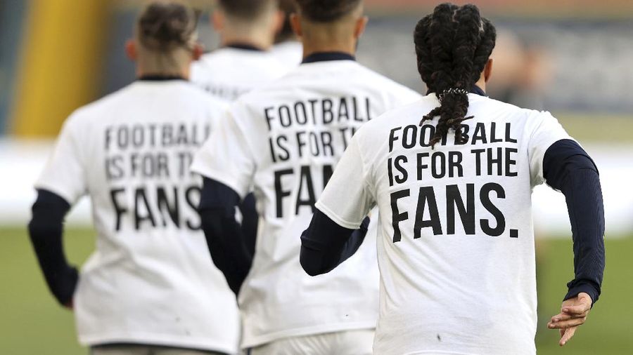 Leeds United players wear t-shirts with the logo 'Football Is For The Fans' as they warm-up ahead of ahead of the English Premier League soccer match between Leeds United and Liverpool at the Elland Road stadium in Leeds, England, Monday, April 19, 2021. (Clive Brunskill/Pool via AP)