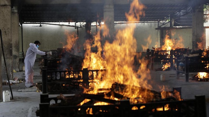 Proses kremasi pasien covid-19 yang meninggal di krematorium, New Delhi, India. Flames rise from cremation pyres of 13 COVID-19 patients who died in a fire that broke out in Vijay Vallabh COVID-19 hospital, at Virar, near Mumbai, India, Friday, April 23, 2021. Delhi has been cremating so many bodies of coronavirus victims that authorities are getting requests to start cutting down trees in city parks, as a second record surge has brought India's tattered healthcare system to its knees. (AP Photo/Rajanish Kakade)