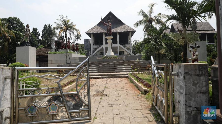 Suasana kondisi museum telekomunikasi yang sudah tidak terpakai di Kawasan TMII, Jakarta, Senin (26/4). Setelah tidak beroperasi akibat pandemi, pengelola membuka kembali TMII dengan menerapkan protokol kesehatan pencegahan COVID-19 dan pembatasan pengunjung.  Pantauan CNBC Indonesia beberapa wahana dan anjungan tidak terawat. TMII yang merupakan aset penting untuk mengajarkan kepada generasi penerus mengenai budaya, seni, dan beragamnya Indonesia. Seperti halnya di museum minyak gas bumi banyak rumput-rumput liar yang tumbuh disekitar bangunan. Mampir ke Anjungan Riau, menyaksikan pemandangan yang kurang lebih sama. Tak ada antrean di loket. Hanya ada beberapa warga yang tertidur di bawah rumah. Kebijakan Presiden Jokowi mengambil alih kembali aset-aset negara dari anak-anak Soeharto menjadi sorotan belakangan. Setelah pimpinan negara yang lalu tak melakukan langkah serupa Jokowi. Pengambil alihan aset taman mini sudah dituangkan dalam Peraturan Presiden (Perpres) Nomor 19 Tahun 2021 tentang mengambil alih pengolahan TMII yang diterbitkan Jokowi.  (CNBC Indonesia/ Muhammad Sabki)