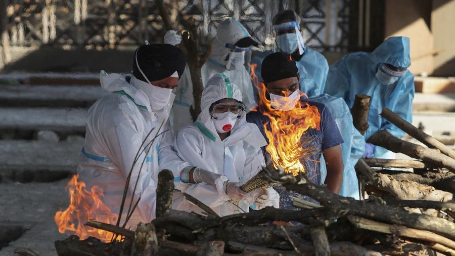 Family members of a person who died due to COVID-19 light the funeral pyre at a crematorium in Jammu, India, Monday, April 26, 2021. (AP Photo/Channi Anand)
