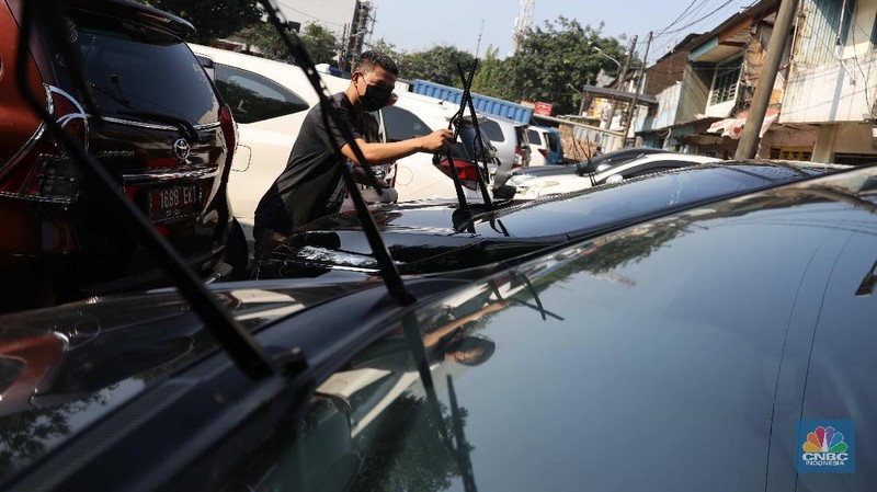 Pekerja membersihkan mobil rental yang terparkir di kawasan Tanjung Priok, Jakarta, Selasa, (27/4). Salah satu pemilik jasa rental mobil rentcartopiq Taufiq mengatakan, musim mudik di bulan ramadhan ini masih sepi order. 