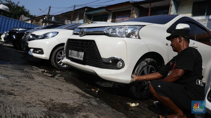 Pekerja membersihkan mobil rental yang terparkir di kawasan Tanjung Priok, Jakarta, Selasa, (27/4). Salah satu pemilik jasa rental mobil rentcartopiq Taufiq mengatakan, musim mudik di bulan ramadhan ini masih sepi order. 