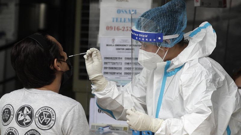 A man carries a sick woman from a pedicab as they bring her to the emergency area of the hospital that is crowded with suspected COVID-19 patients in Manila, Philippines on Monday, April 26, 2021. COVID-19 infections in the Philippines surged past 1 million Monday in the latest grim milestone as officials assessed whether to extend a monthlong lockdown in Manila and outlying provinces amid a deadly spike or relax it to fight recession, joblessness and hunger. (AP Photo/Aaron Favila)