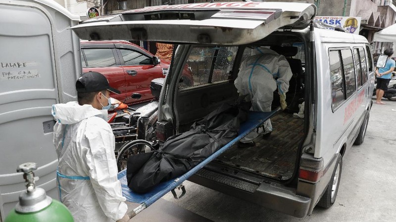 A man carries a sick woman from a pedicab as they bring her to the emergency area of the hospital that is crowded with suspected COVID-19 patients in Manila, Philippines on Monday, April 26, 2021. COVID-19 infections in the Philippines surged past 1 million Monday in the latest grim milestone as officials assessed whether to extend a monthlong lockdown in Manila and outlying provinces amid a deadly spike or relax it to fight recession, joblessness and hunger. (AP Photo/Aaron Favila)