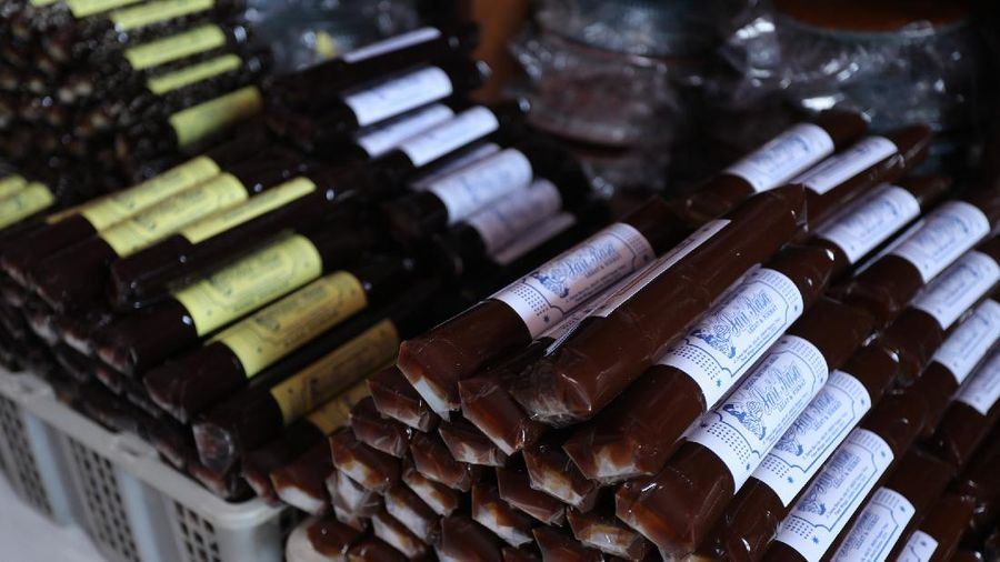 Pekerja menyelesaikan proses pembuatan dodol Betawi di rumah Produksi Pondok Dodol Sari Rasa Ibu Yuyun di Jakarta, Selasa (27/4/2021). Produksi dodol Betawi mengalami peningkatan permintaan sekitar 80 persen menjelang Hari Raya Idul Fitri dari semula hanya memproduksi dua wajan, kini mampu menyelesaikan 18 wajan dalam sehari. Harga dodol mulai dijual dari harga 20 ribu hingga 110 ribu dan memiliki 5 varian rasa. Salah satu karyawan mengatakan 