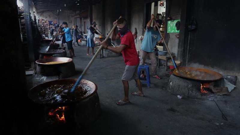 Pekerja menyelesaikan proses pembuatan dodol Betawi di rumah Produksi Pondok Dodol Sari Rasa Ibu Yuyun di Jakarta, Selasa (27/4/2021). Produksi dodol Betawi mengalami peningkatan permintaan sekitar 80 persen menjelang Hari Raya Idul Fitri dari semula hanya memproduksi dua wajan, kini mampu menyelesaikan 18 wajan dalam sehari. Harga dodol mulai dijual dari harga 20 ribu hingga 110 ribu dan memiliki 5 varian rasa. Salah satu karyawan mengatakan 