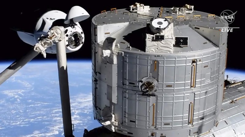 In this image made from NASA TV, the SpaceX Crew Dragon spacecraft, left, approaches to the international space station, Saturday, April 24, 2021. The recycled SpaceX capsule carrying four astronauts arrived at the International Space Station on Saturday, the third high-flying taxi ride in less than a year for Elon Musk's company.(NASA via AP)