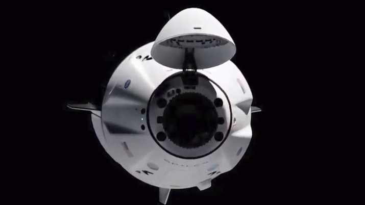 Pesawat luar angkasa SpaceX Crew Dragon terlihat dari stasiun luar angkasa internasional, Sabtu (24/4/2021).(NASA via AP) In this image made from NASA TV, the SpaceX Crew Dragon spacecraft is seen from the international space station, Saturday, April 24, 2021. The recycled SpaceX capsule carrying four astronauts has arrived at the International Space Station, a day after launching from Florida. (NASA via AP)