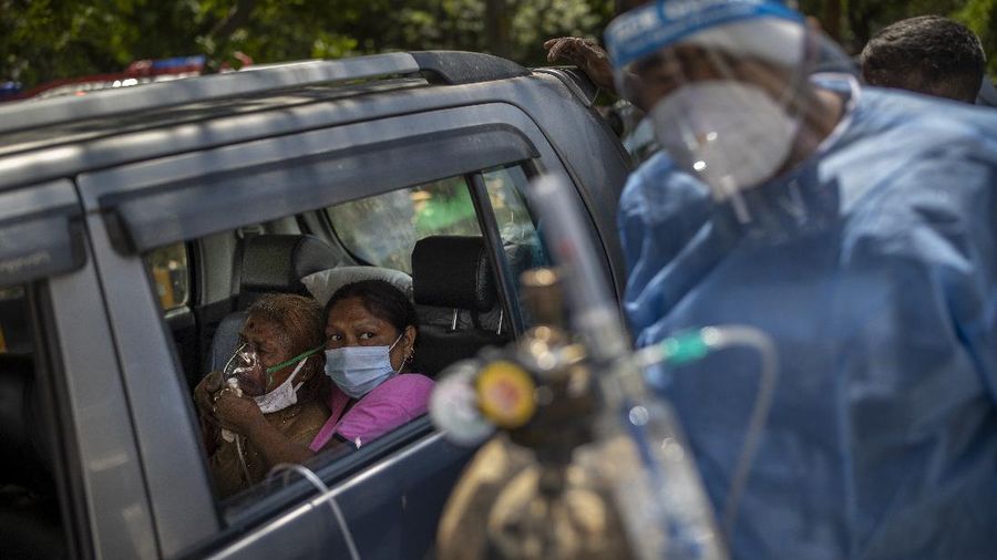 A patient receives oxygen inside a car provided by a Gurdwara, a Sikh place of worship, in New Delhi, India, Saturday, April 24, 2021. India’s medical oxygen shortage has become so dire that this gurdwara began offering free breathing sessions with shared tanks to COVID-19 patients waiting for a hospital bed. They arrive in their cars, on foot or in three-wheeled taxis, desperate for a mask and tube attached to the precious oxygen tanks outside the gurdwara in a neighborhood outside New Delhi. (AP Photo/Altaf Qadri)