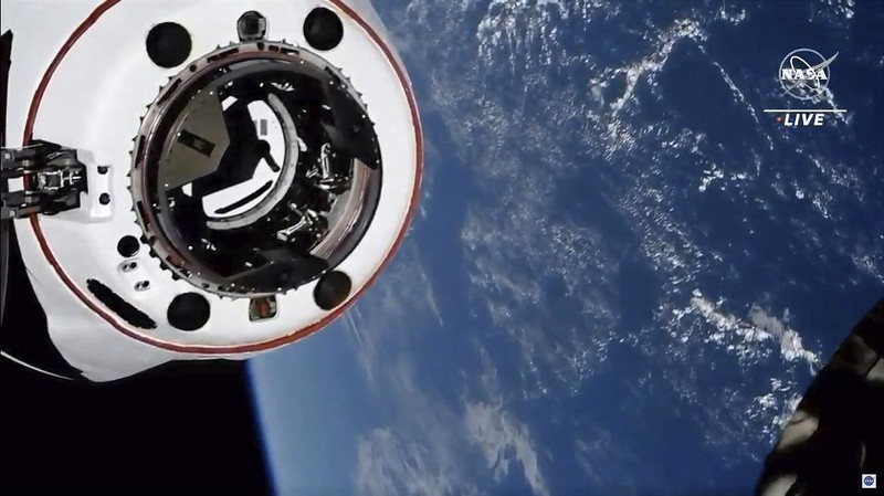 In this image made from NASA TV, the SpaceX Crew Dragon spacecraft, left, approaches to the international space station, Saturday, April 24, 2021. The recycled SpaceX capsule carrying four astronauts arrived at the International Space Station on Saturday, the third high-flying taxi ride in less than a year for Elon Musk's company.(NASA via AP)