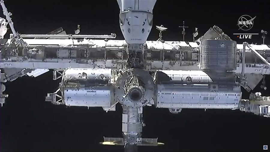 In this image made from NASA TV, the SpaceX Crew Dragon spacecraft, left, approaches to the international space station, Saturday, April 24, 2021. The recycled SpaceX capsule carrying four astronauts arrived at the International Space Station on Saturday, the third high-flying taxi ride in less than a year for Elon Musk's company.(NASA via AP)