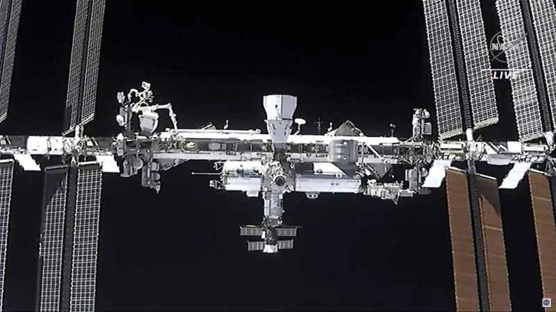 In this image made from NASA TV, the SpaceX Crew Dragon spacecraft, left, approaches to the international space station, Saturday, April 24, 2021. The recycled SpaceX capsule carrying four astronauts arrived at the International Space Station on Saturday, the third high-flying taxi ride in less than a year for Elon Musk's company.(NASA via AP)