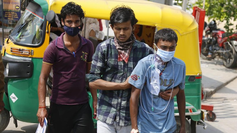 Health workers bring a patient to be admitted at a government COVID-19 hospital in Ahmedabad, India, Tuesday, April 27, 2021. Coronavirus cases in India are surging faster than anywhere else in the world. (AP Photo/Ajit Solanki)