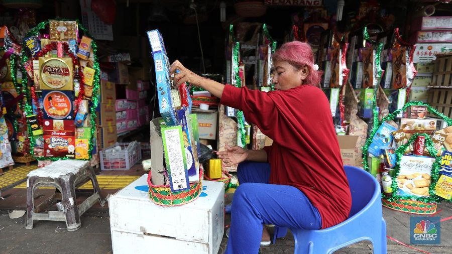Pedagang menyelesaikan pembungkusan parcel di kawasan Cikini, Jakarta, Rabu (28/4/2021). Pedagang parcel musiman tersebut menjual parcelnya mulai dari harga 250 ribu hingga 3 juta tergantung dari model parcel yang diminta pembeli. Isi parcel pun beragam, mulai dari makanan ringan, minuman hingga piring dan gelas. Namun para pedagang mulai ramai pesanan H-14 untuk perkantoran dan perorangan. Hal serupa juga terjadi di Jl. Barito penjual parcel dikawasan ini mulai kebanjiran order, salah satunya Yuni pedagang asal Jawa tengah mengaku dirinya ramai pesanan untuk perkantoran hingga perorangan. 