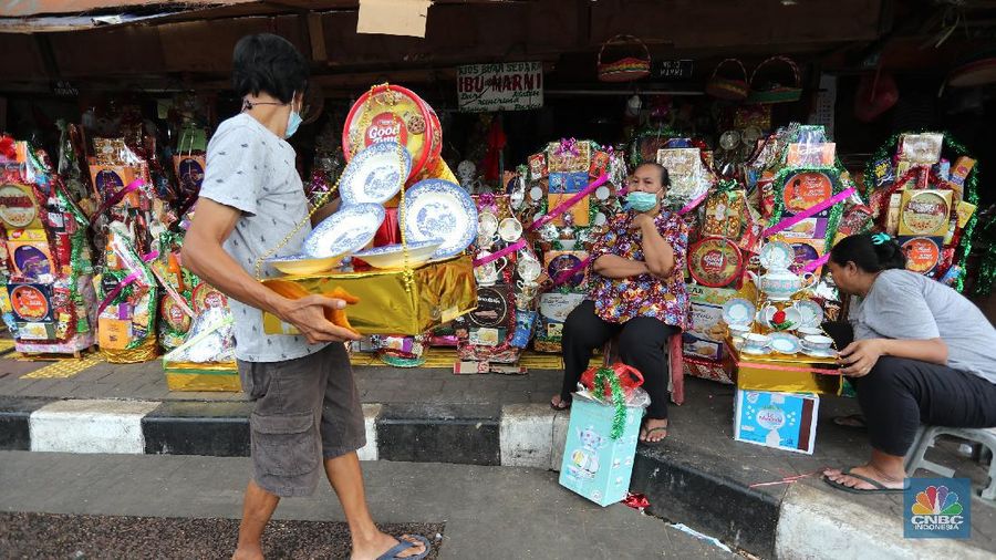 Pedagang menyelesaikan pembungkusan parcel di kawasan Barito Jakarta, Rabu (28/4/2021). Pedagang parcel musiman tersebut menjual parcelnya mulai dari harga 250 ribu hingga 3 juta tergantung dari model parcel yang diminta pembeli. Isi parcel pun beragam, mulai dari makanan ringan, minuman hingga piring dan gelas. Namun para pedagang mulai ramai pesanan H-14 untuk perkantoran dan perorangan. Hal serupa juga terjadi di Jl. Barito penjual parcel dikawasan ini mulai kebanjiran order, salah satunya Yuni pedagang asal Jawa tengah mengaku dirinya ramai pesanan untuk perkantoran hingga perorangan. 