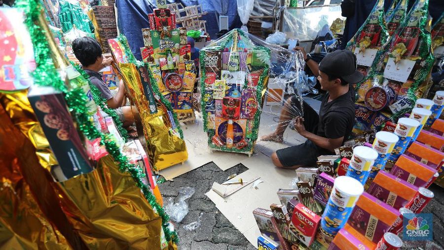 Pedagang menyelesaikan pembungkusan parcel di kawasan Cikini, Jakarta, Rabu (28/4/2021). Pedagang parcel musiman tersebut menjual parcelnya mulai dari harga 250 ribu hingga 3 juta tergantung dari model parcel yang diminta pembeli. Isi parcel pun beragam, mulai dari makanan ringan, minuman hingga piring dan gelas. Namun para pedagang mulai ramai pesanan H-14 untuk perkantoran dan perorangan. Hal serupa juga terjadi di Jl. Barito penjual parcel dikawasan ini mulai kebanjiran order, salah satunya Yuni pedagang asal Jawa tengah mengaku dirinya ramai pesanan untuk perkantoran hingga perorangan. 