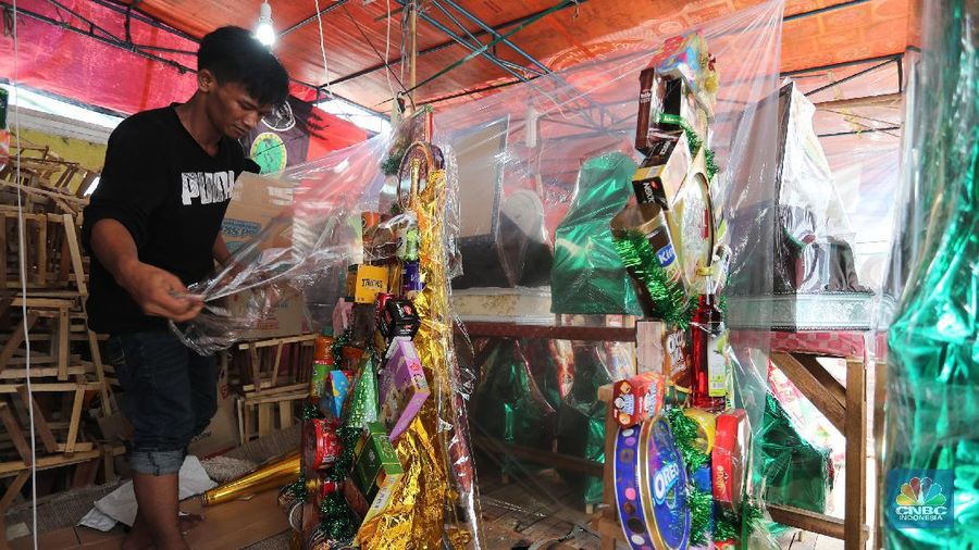 Pedagang menyelesaikan pembungkusan parcel di kawasan Cikini, Jakarta, Rabu (28/4/2021). Pedagang parcel musiman tersebut menjual parcelnya mulai dari harga 250 ribu hingga 3 juta tergantung dari model parcel yang diminta pembeli. Isi parcel pun beragam, mulai dari makanan ringan, minuman hingga piring dan gelas. Namun para pedagang mulai ramai pesanan H-14 untuk perkantoran dan perorangan. Hal serupa juga terjadi di Jl. Barito penjual parcel dikawasan ini mulai kebanjiran order, salah satunya Yuni pedagang asal Jawa tengah mengaku dirinya ramai pesanan untuk perkantoran hingga perorangan. 