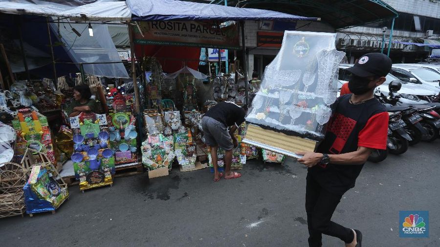 Pedagang menyelesaikan pembungkusan parcel di kawasan Cikini, Jakarta, Rabu (28/4/2021). Pedagang parcel musiman tersebut menjual parcelnya mulai dari harga 250 ribu hingga 3 juta tergantung dari model parcel yang diminta pembeli. Isi parcel pun beragam, mulai dari makanan ringan, minuman hingga piring dan gelas. Namun para pedagang mulai ramai pesanan H-14 untuk perkantoran dan perorangan. Hal serupa juga terjadi di Jl. Barito penjual parcel dikawasan ini mulai kebanjiran order, salah satunya Yuni pedagang asal Jawa tengah mengaku dirinya ramai pesanan untuk perkantoran hingga perorangan. 