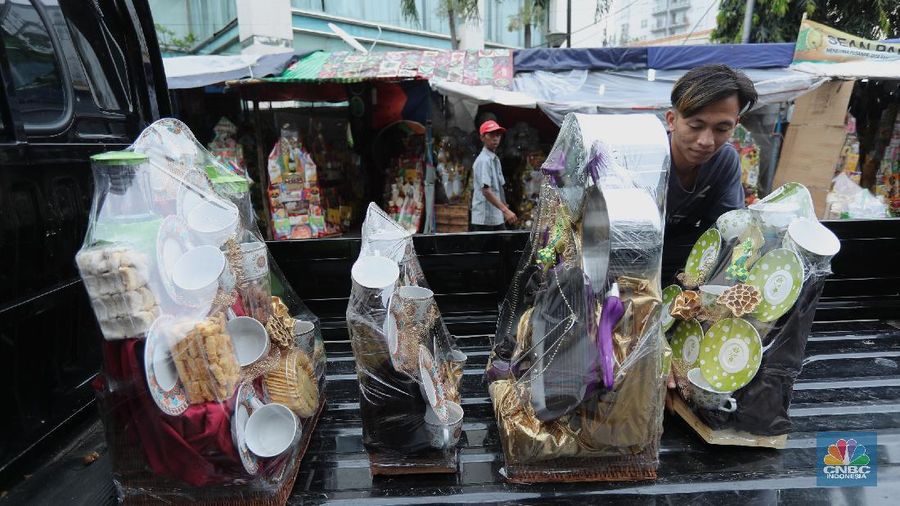 Pedagang menyelesaikan pembungkusan parcel di kawasan Cikini, Jakarta, Rabu (28/4/2021). Pedagang parcel musiman tersebut menjual parcelnya mulai dari harga 250 ribu hingga 3 juta tergantung dari model parcel yang diminta pembeli. Isi parcel pun beragam, mulai dari makanan ringan, minuman hingga piring dan gelas. Namun para pedagang mulai ramai pesanan H-14 untuk perkantoran dan perorangan. Hal serupa juga terjadi di Jl. Barito penjual parcel dikawasan ini mulai kebanjiran order, salah satunya Yuni pedagang asal Jawa tengah mengaku dirinya ramai pesanan untuk perkantoran hingga perorangan. 