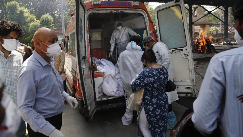 Health workers bring a patient to be admitted at a government COVID-19 hospital in Ahmedabad, India, Tuesday, April 27, 2021. Coronavirus cases in India are surging faster than anywhere else in the world. (AP Photo/Ajit Solanki)