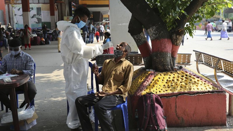 Health workers bring a patient to be admitted at a government COVID-19 hospital in Ahmedabad, India, Tuesday, April 27, 2021. Coronavirus cases in India are surging faster than anywhere else in the world. (AP Photo/Ajit Solanki)