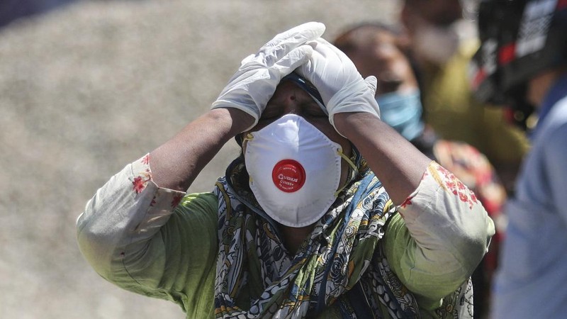 Health workers bring a patient to be admitted at a government COVID-19 hospital in Ahmedabad, India, Tuesday, April 27, 2021. Coronavirus cases in India are surging faster than anywhere else in the world. (AP Photo/Ajit Solanki)