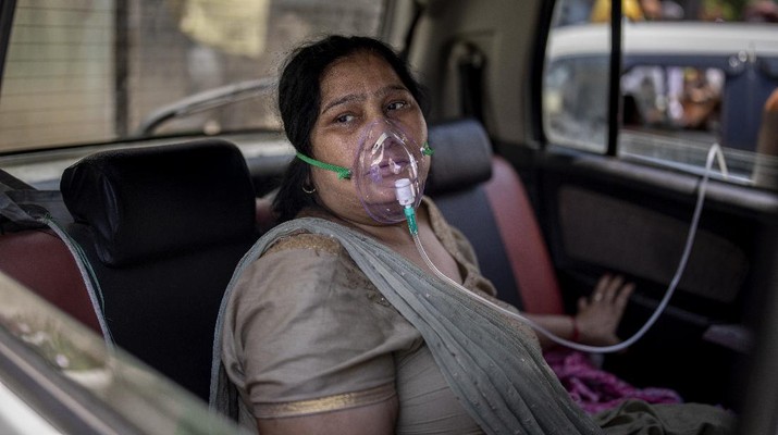 Seorang pasien COVID-19 duduk di dalam mobil dan bernapas dengan bantuan oksigen yang disediakan oleh Gurdwara, rumah ibadah Sikh, di New Delhi, India. (AP / Altaf Qadri) FILE - In this April 24, 2021, file photo, a COVID-19 patient sits inside a car and breathes with the help of oxygen provided by a Gurdwara, a Sikh house of worship, in New Delhi, India. India crossed a grim milestone Wednesday, April 28, 2021 of 200,000 people lost to the coronavirus as a devastating surge of new infections tears through dense cities and rural areas alike and overwhelms health care systems on the brink of collapse. (AP Photo/Altaf Qadri)