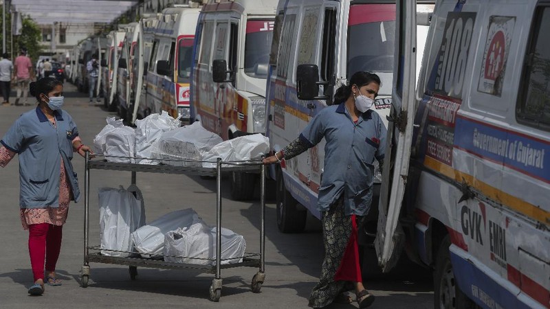 Health workers bring a patient to be admitted at a government COVID-19 hospital in Ahmedabad, India, Tuesday, April 27, 2021. Coronavirus cases in India are surging faster than anywhere else in the world. (AP Photo/Ajit Solanki)