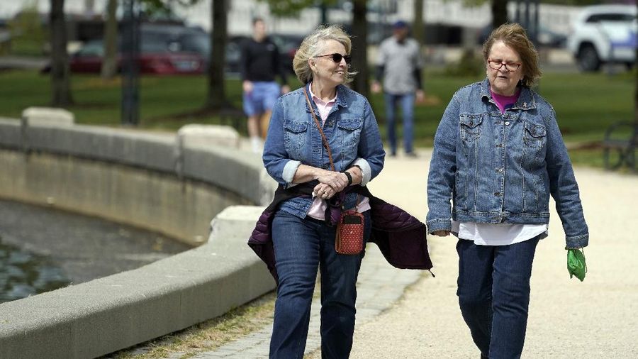 Donna Anderson, left, walks with her friend Christine White, Tuesday, April 27, 2021, in Olympia, Wash. Both women said they are fully vaccinated and have felt comfortable recently in not wearing masks when they are outdoors. On Tuesday, the Centers for Disease Control and Prevention eased its guidelines on the wearing of masks outdoors, saying fully vaccinated Americans don't need to cover their faces anymore unless they are in a big crowd of strangers. (AP Photo/Ted S. Warren)