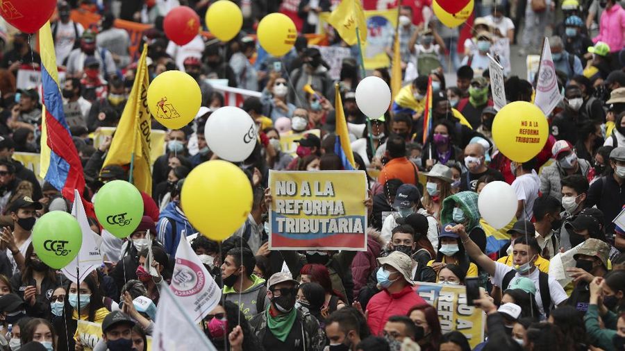 Protesters, one with a sign that reads in Spanish 