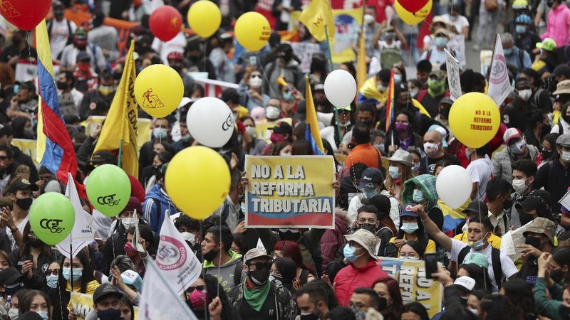 Protesters, one with a sign that reads in Spanish 