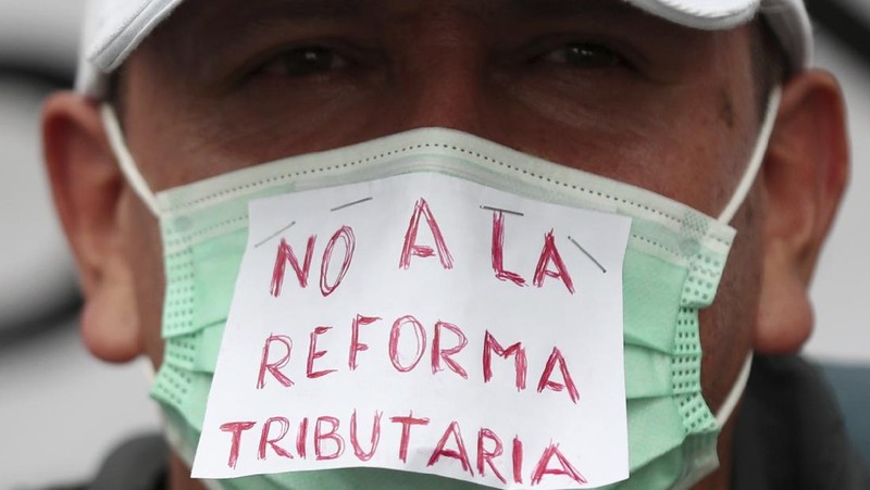 Protesters, one with a sign that reads in Spanish 