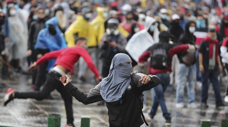 Protesters, one with a sign that reads in Spanish 