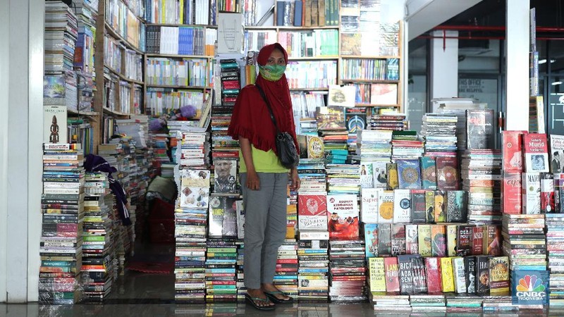 Sejumlah pedagang merapikan buku bacaan di Pasar Kenari, Jakarta, Kamis (29/4/2021). Pasar Buku Kenari sangat sepi dari pengunjung di tengah masa pandemi Covid-19. Pantauan CNBC Indonesia sesekali ada warga yang melihat - lihat bahkan membeli buku satu atau dua di Pasar ini. Pasar Buku Kenari menjual berbagai macam buku mulai buku bacaan hingga komik, buku yang dijual merupakan buku bekas ataupun buku baru. Novelia (19) mewakili pedagang buku yang terdampak pandemi covid mengatakan 