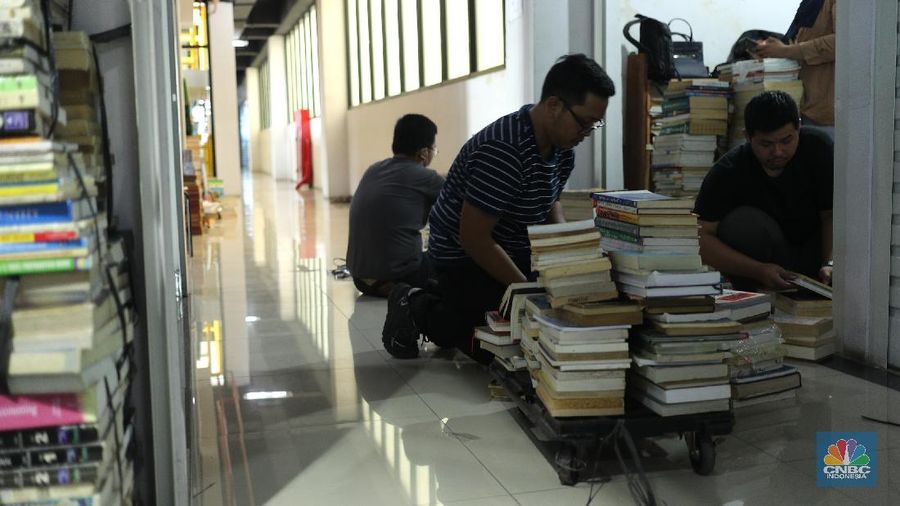 Sejumlah pedagang merapikan buku bacaan di Pasar Kenari, Jakarta, Kamis (29/4/2021). Pasar Buku Kenari sangat sepi dari pengunjung di tengah masa pandemi Covid-19. Pantauan CNBC Indonesia sesekali ada warga yang melihat - lihat bahkan membeli buku satu atau dua di Pasar ini. Pasar Buku Kenari menjual berbagai macam buku mulai buku bacaan hingga komik, buku yang dijual merupakan buku bekas ataupun buku baru. Novelia (19) mewakili pedagang buku yang terdampak pandemi covid mengatakan 