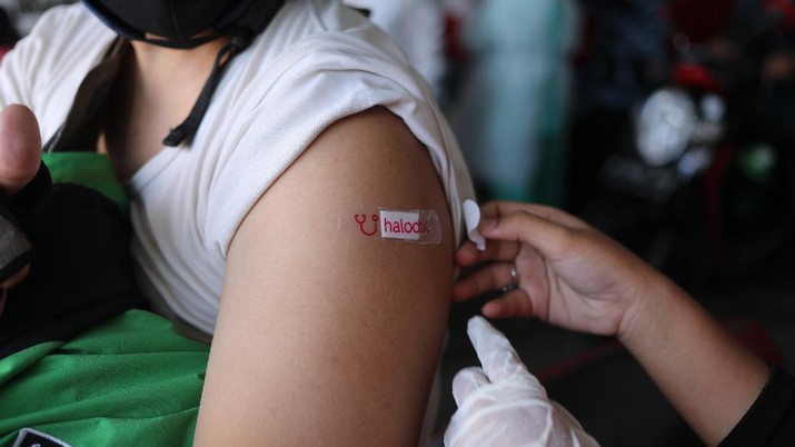 Petugas kesehatan menyuntikkan vaksin dosis pertama kepada driver Gojek di Kemayoran, Jakarta, Kamis (29/4/2021). Halodoc dan Gojek berkolaborasi hadirkan pos pelayanan Covid-19 melalui metode Drive thru dan melayani 1.500 dosis vaksin setiap harinya untuk memperkuat upaya Kementerian Kesehatan RI dalam mempercepat Vaksinasi Covid-19 di Indonesia.  (CNBC Indonesia/ Tri Susilo)