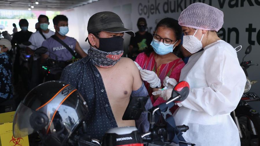 Petugas kesehatan menyuntikkan vaksin dosis pertama kepada driver Gojek di Kemayoran, Jakarta, Kamis (29/4/2021). Halodoc dan Gojek berkolaborasi hadirkan pos pelayanan Covid-19 melalui metode Drive thru dan melayani 1.500 dosis vaksin setiap harinya untuk memperkuat upaya Kementerian Kesehatan RI dalam mempercepat Vaksinasi Covid-19 di Indonesia.  (CNBC Indonesia/ Tri Susilo)