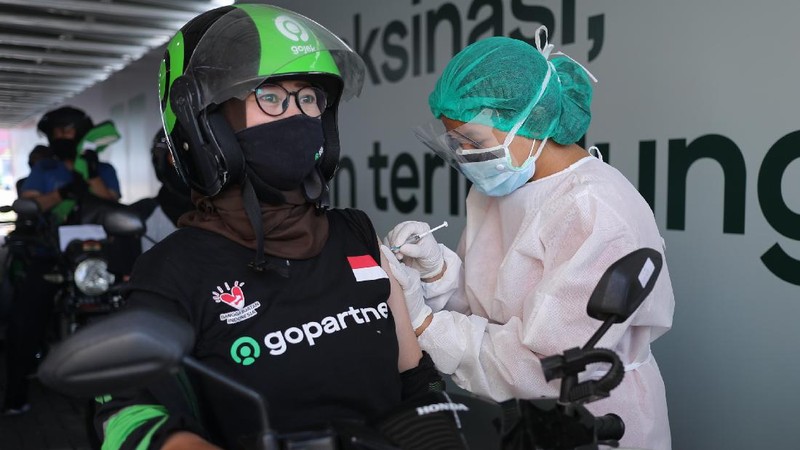 Petugas kesehatan menyuntikkan vaksin dosis pertama kepada driver Gojek di Kemayoran, Jakarta, Kamis (29/4/2021). Halodoc dan Gojek berkolaborasi hadirkan pos pelayanan Covid-19 melalui metode Drive thru dan melayani 1.500 dosis vaksin setiap harinya untuk memperkuat upaya Kementerian Kesehatan RI dalam mempercepat Vaksinasi Covid-19 di Indonesia.  (CNBC Indonesia/ Tri Susilo)